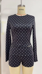 Detailed view of the black and white polka dot two-piece long sleeve top and shorts set