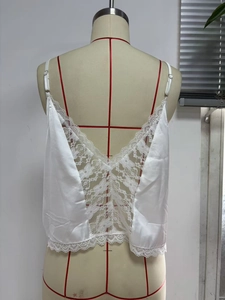 Dettaglio canotta in raso bianco con pizzo intricato sulla schiena scoperta