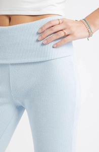 Gros plan détaillé du tissu en maille côtelée bleu clair sur un pantalon évasé taille haute