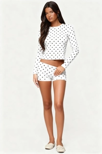 Close-up of women's two-piece loungewear with stylish black polka dots on white fabric