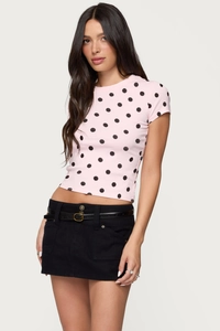 Close-up of pink slim-fit t-shirt with black polka dot print and stylish leather belt