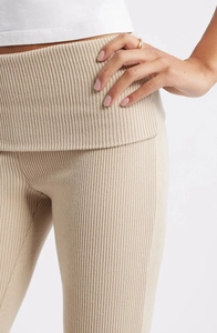 Détail du pantalon en maille côtelée beige montrant la taille haute et la texture