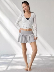 Chic white polka dot wrap top with long sleeves paired with grey pleated mini skirt