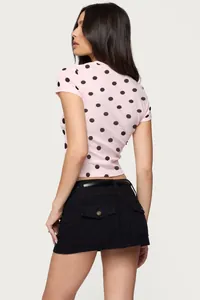 Detail view of pink polka dot slim T-shirt and black high-waisted mini skirt set