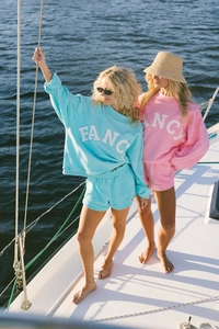 Blue and pink sweatshirt sets with FANCY lettering on a sunny yacht background