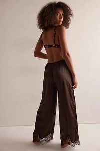 Detail of elegant floral camisole and satin trousers with delicate black lace hem finish