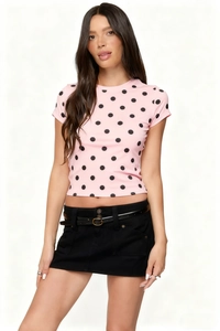 Close-up of pink polka dot t-shirt fabric texture with slim black mini skirt