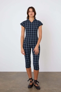 Détail d'un ensemble à carreaux bleus avec haut à manches courtes et pantalon court ajusté