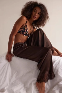 Detail of rose floral bra top and satin trousers with delicate lace trim at the hem