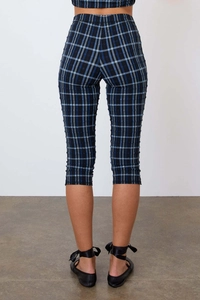 Détail du pantalon 7/8 à carreaux bleu et noir montrant le tissu extensible et la coupe slim