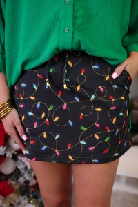 Detail of Christmas skirt with colorful light bulb print, elastic waist and gold drawstrings
