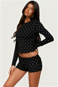Detailed side view of women's black polka dot loungewear set with long sleeve top and shorts