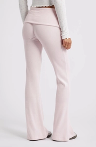 Détail du pantalon évasé en maille côtelée rose avec une taille haute repliée élégante