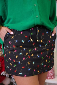 Detail of high waisted Christmas skirt featuring colorful bulb print and drawstrings