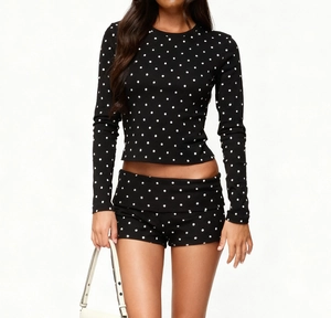 Detailed close-up of knitted fabric texture on black polka dot lounge set for women