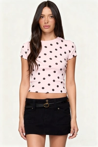 Detailed view of pink polka dot crop top with slim fit and round neck on a model