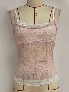 Detail of light pink floral lace camisole with scalloped white trim and double straps