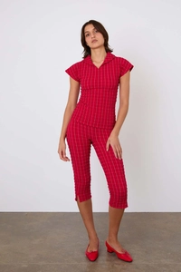 Détail de la texture du tissu plissé rouge foncé sur un ensemble ajusté pour femmes