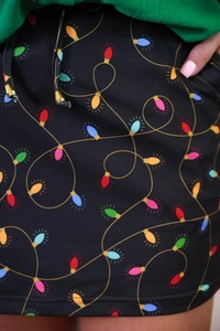 Detailed view of Christmas string light pattern on high-waisted skirt with gold-tipped drawstrings