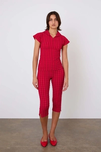 Détail de l'ensemble polo rouge montrant la texture plissée du pantalon court