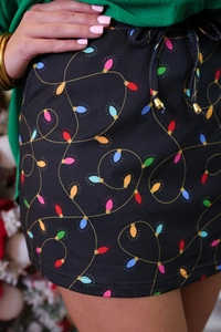 Detail shot of high-waist Christmas skirt featuring festive lights print and gold drawstring ends