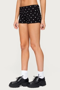 Detail of high-waist black polka dot shorts made of soft elastic knit cotton fabric