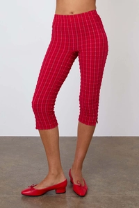 Détail du pantalon écossais rouge avec taille haute et petite fente latérale au bas