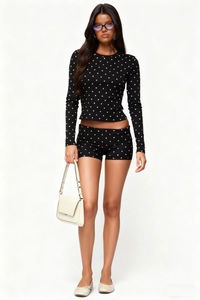 Detailed full-body view of a women's black and white polka dot two-piece slim fit set