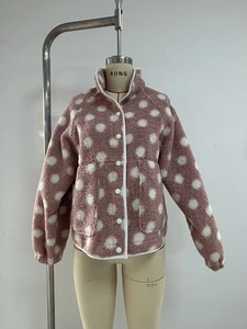 Detail of pink fleece jacket showing large white polka dots and round button closure