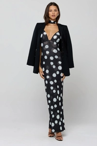Detail of elegant black and white polka dot maxi dress with matching halter neck and blazer