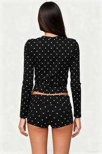 Back view of slim fit women's two-piece loungewear with white polka dots on black fabric