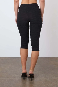 Gros plan sur le pantalon capri noir à taille haute avec motif à carreaux texturé