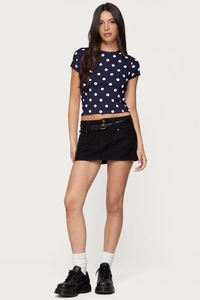 Close-up of retro navy blue polka dot slim fit t-shirt with a belted black mini skirt