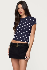 Detailed close-up of navy blue polka dot slim-fit top paired with black belted mini skirt