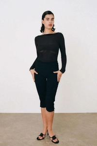 Haut chic en tricot noir à manches longues avec pantalon court ajusté et sandales à fleurs