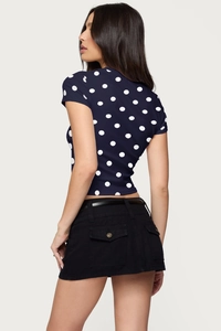 Detail view of cropped navy polka dot top and denim mini skirt with belt from the back