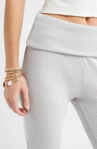 Gros plan détaillé du tissu en maille côtelée gris clair avec taille haute à revers tendance