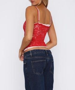 Detail shot of a red lace camisole featuring light pink trim and delicate thin straps
