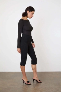 Vue latérale du pantalon court noir avec tissu texturé à carreaux et fentes aux chevilles