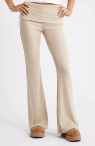 Détail de la taille rabattable et de la texture côtelée du pantalon évasé en maille beige