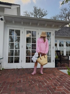Outdoor shot of pink loose sweatshirt with DANCE pattern and woven tote bag for casual style