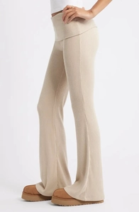 Détail du pantalon évasé en maille côtelée beige avec taille repliée et coupe ajustée