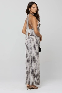 Detailed view of the backless halter design and purple polka dot pattern on the long dress