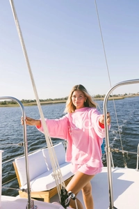 Detail of pink cotton sweatshirt set with white lettering on a luxury yacht deck