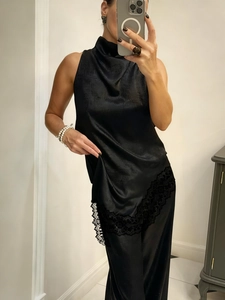 Detail of elegant black satin halter top with delicate lace hem and matching trousers