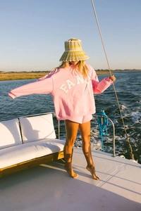 Pink oversized sweatshirt and shorts set with FAN lettering on a yacht deck
