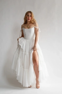 Détail de la robe corset blanche à épaules dénudées avec volants superposés et lacets