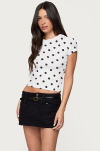 Close-up of slim fit white polka dot t-shirt paired with a black denim mini skirt