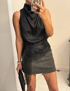 Detail of black satin halter top with draped neck and grey tweed lace mini skirt