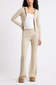 Gros plan sur la texture du tricot côtelé beige et les détails de la taille haute